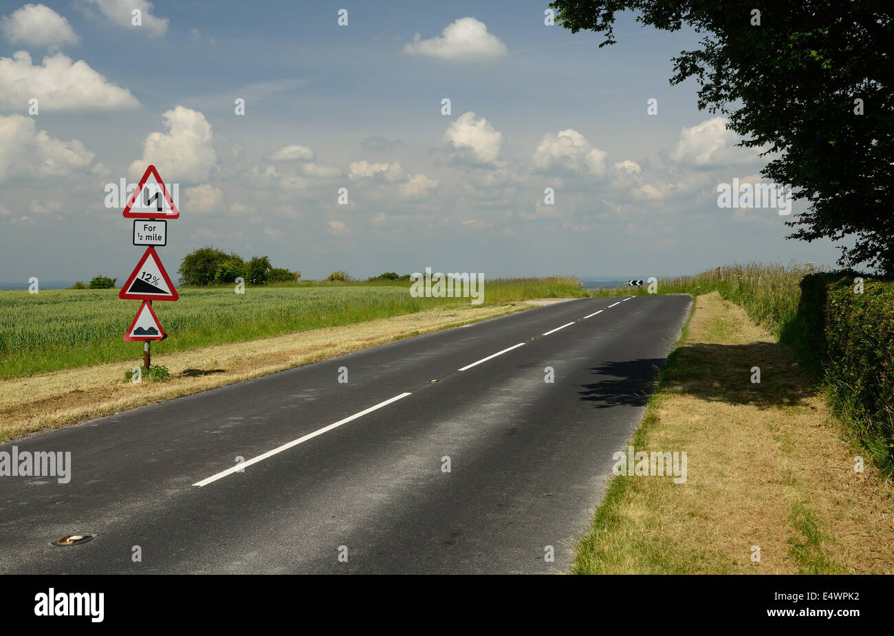 Country road approaching sharp bend and steep gradient. Stock Photo