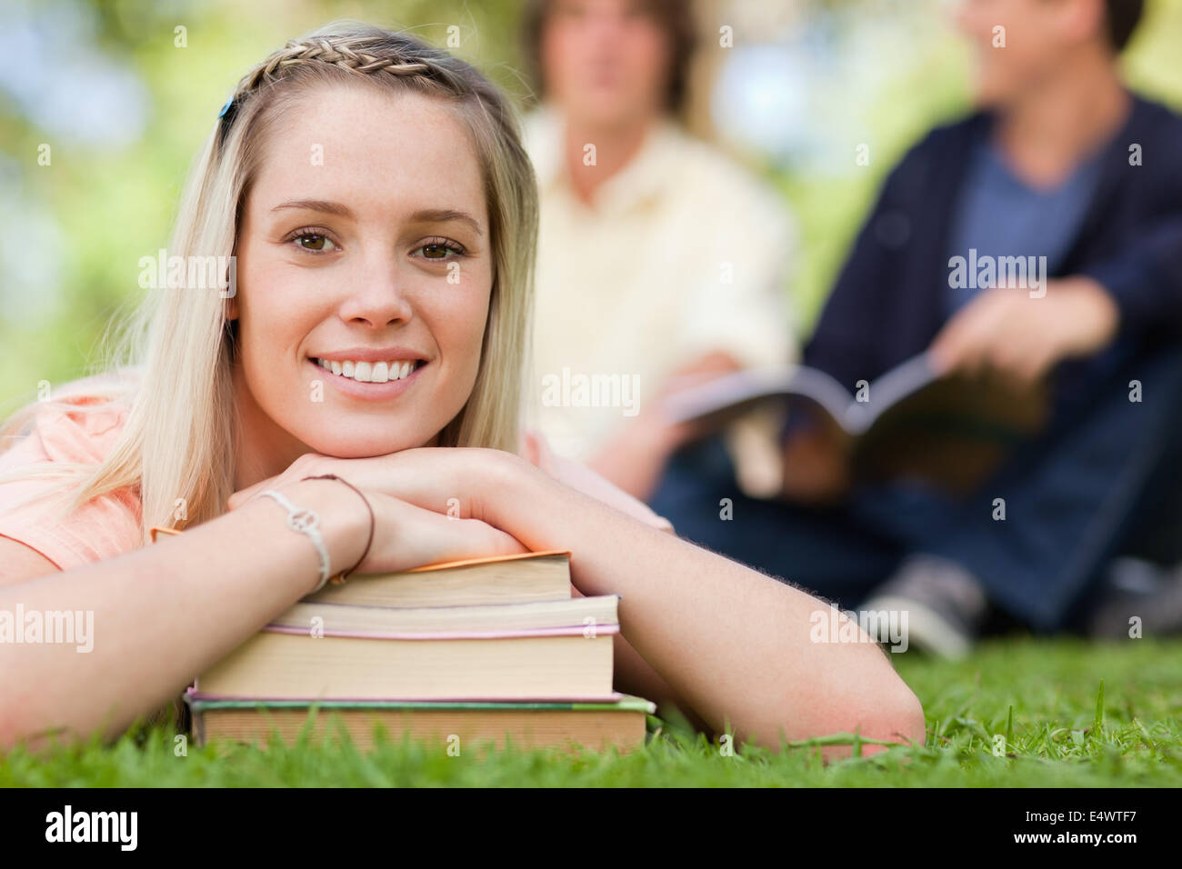 Portrait of a girl lying head on her books Stock Photo - Alamy