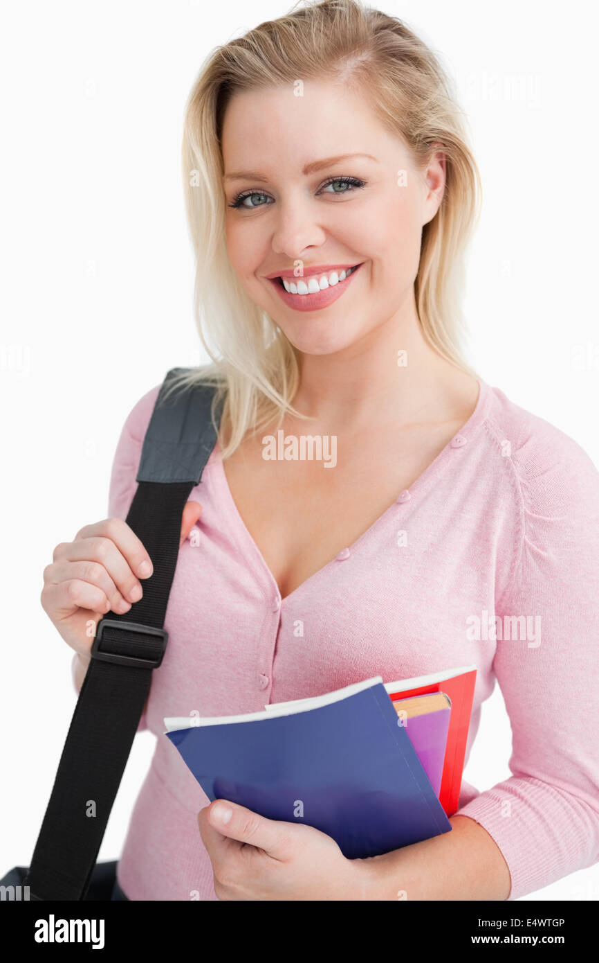 Smiling young woman holding school books Stock Photo - Alamy