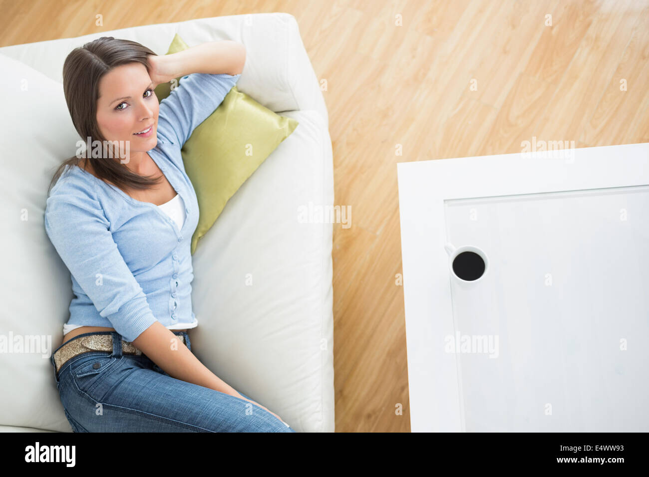 Bruenette woman lying on sofa Stock Photo