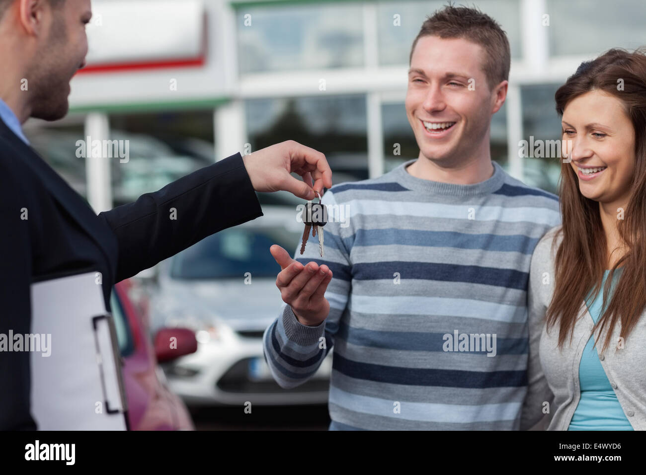 Couple receiving car keys by a dealer Stock Photo
