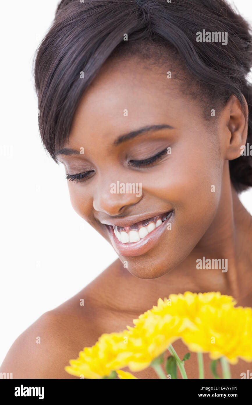 Woman smiling while holding yellow flowers Stock Photo - Alamy