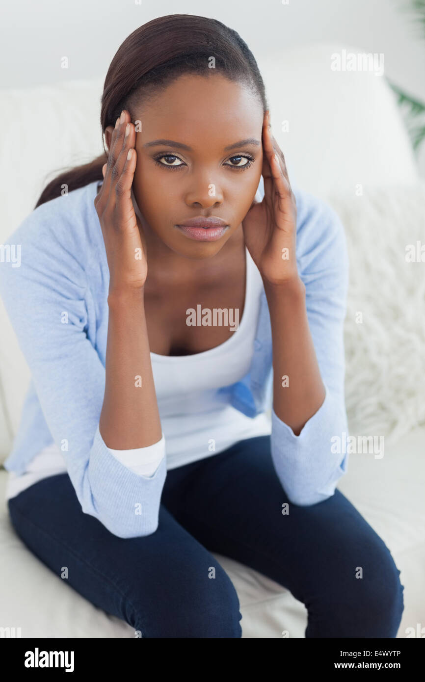 Black woman putting hands on temples Stock Photo - Alamy
