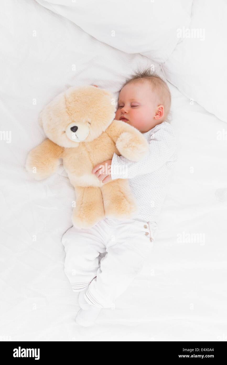 Baby sleeping while holding a teddy bear Stock Photo - Alamy