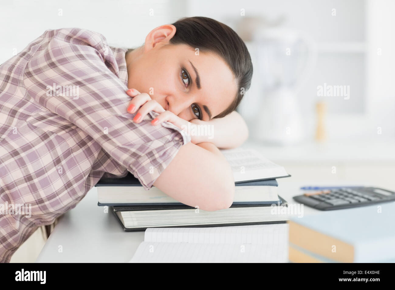 Woman leaning her head on books Stock Photo - Alamy