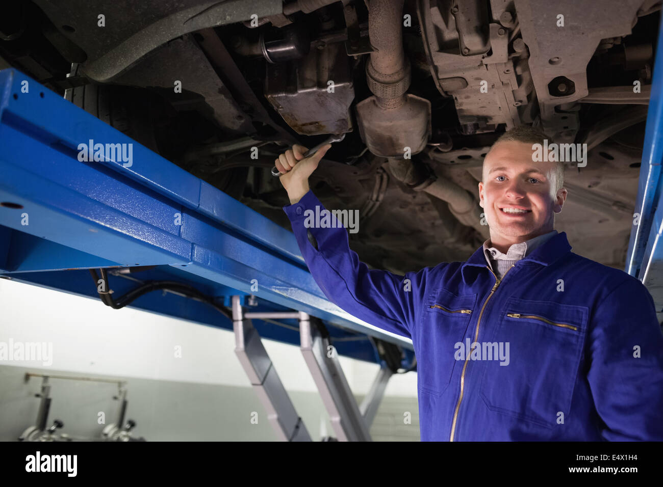 Smiling mechanic repairing with a spanner Stock Photo - Alamy