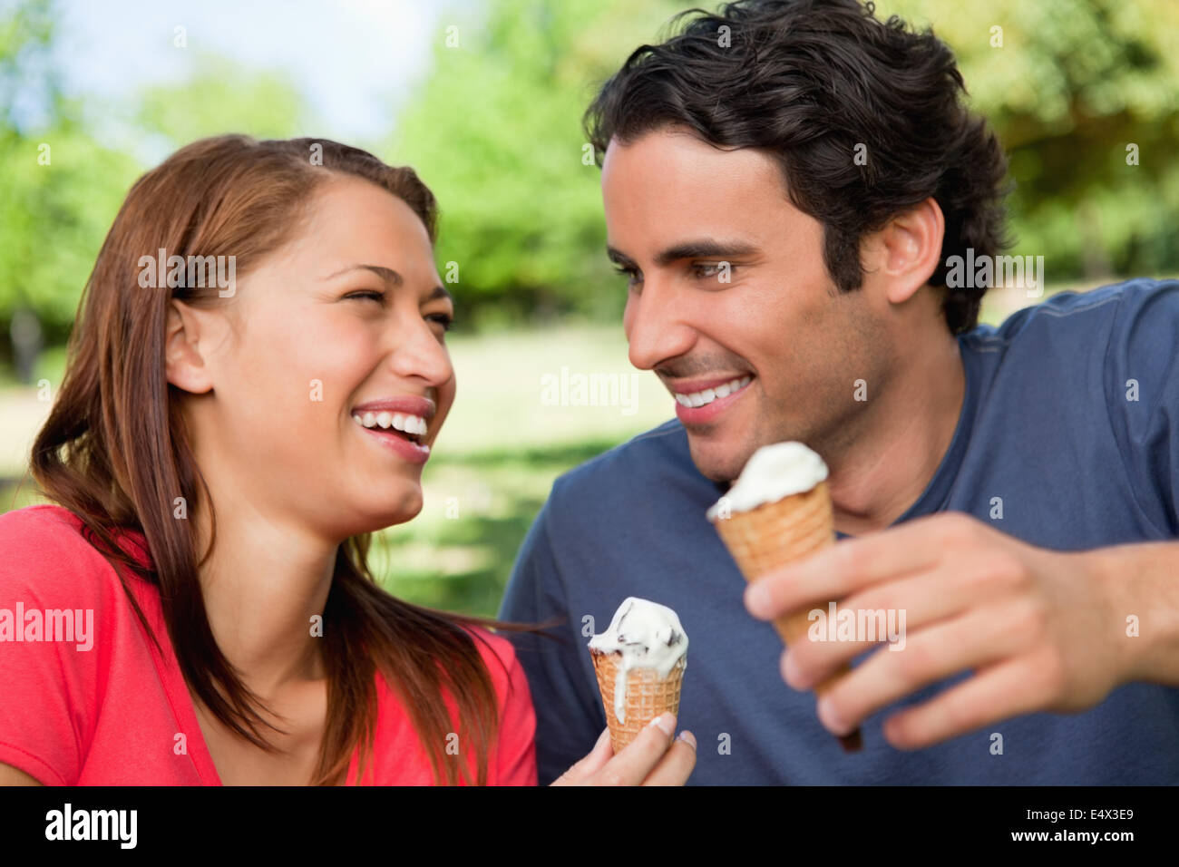 Two friends laughing while holding ice cream Stock Photo Alamy