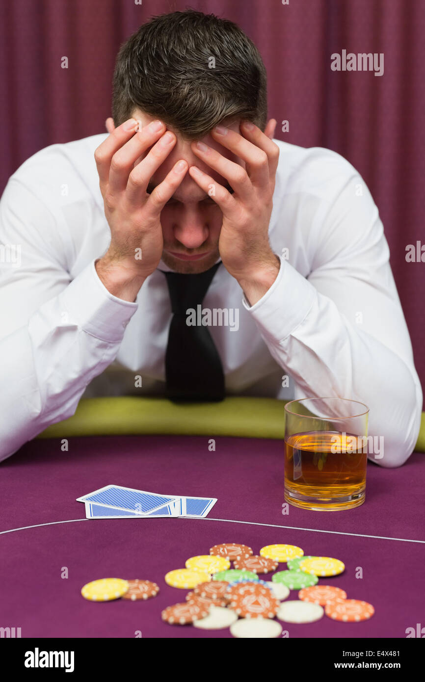 Man leaning on poker table looking worried Stock Photo Alamy