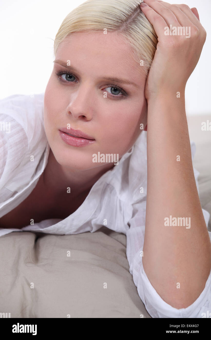 Blond woman laid on bed Stock Photo