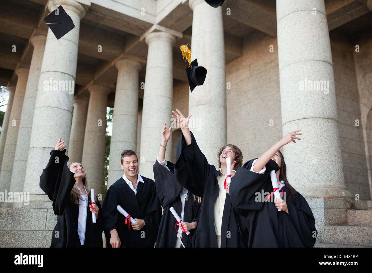 Graduates throwing their hats in the sky Stock Photo Alamy