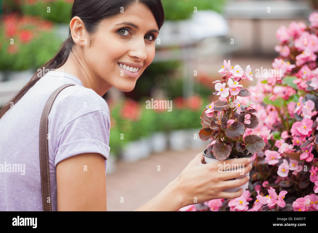 Woman smiling while holding a flower Stock Photo - Alamy
