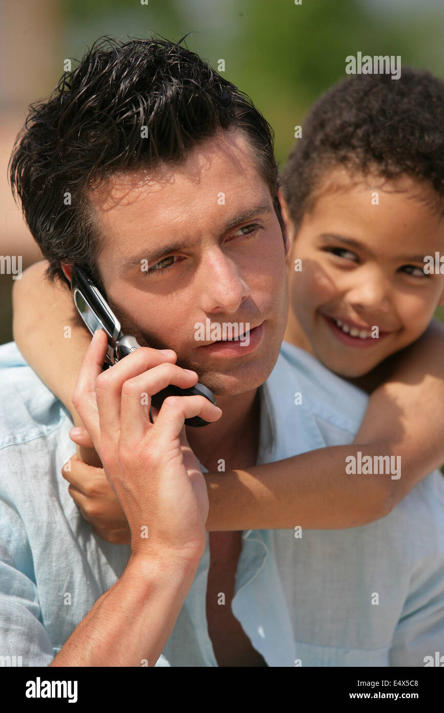 man on phone with little metis boy Stock Photo Alamy