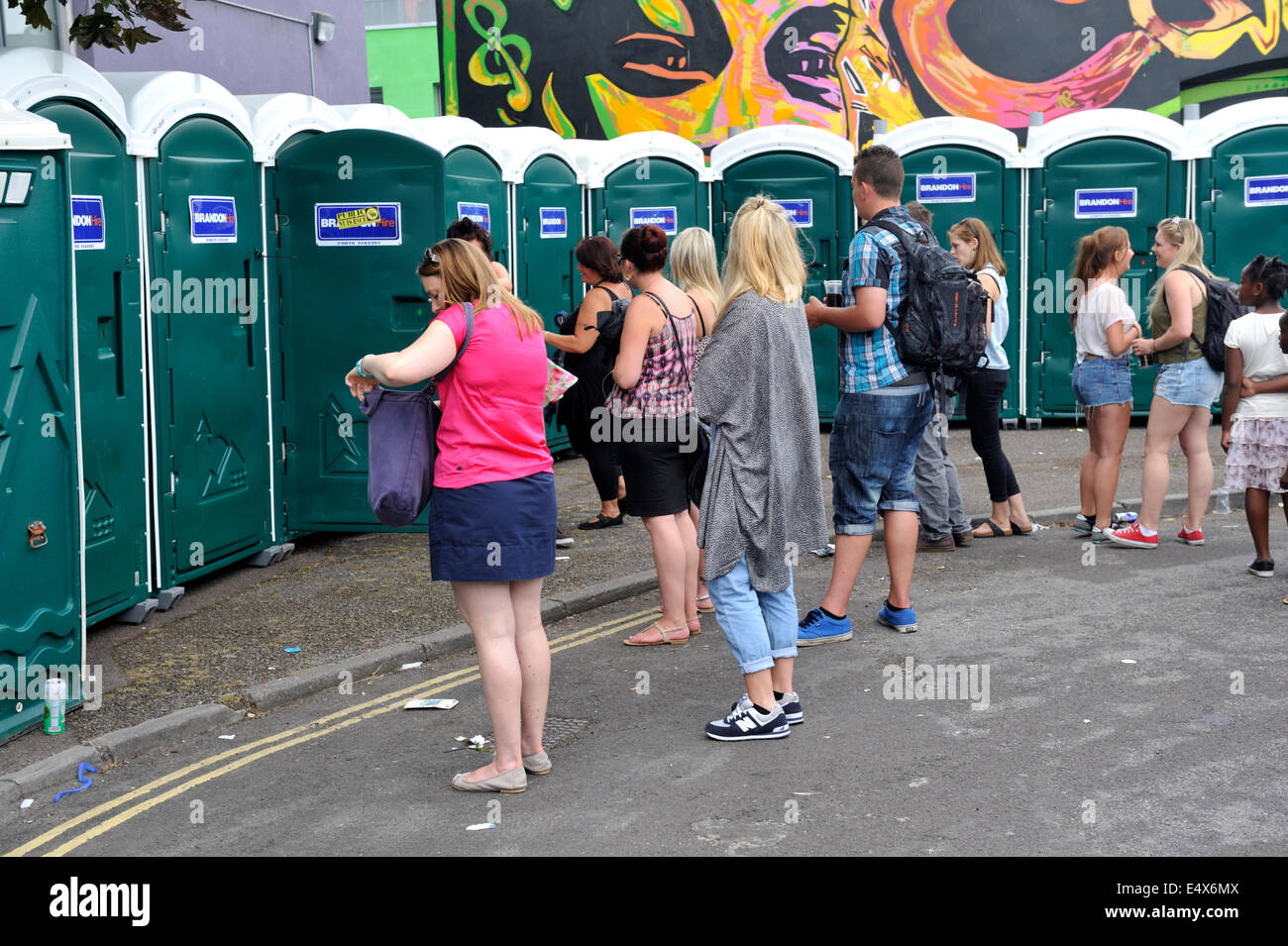 People waiting for portable toilets at street festival, UK Stock Photo