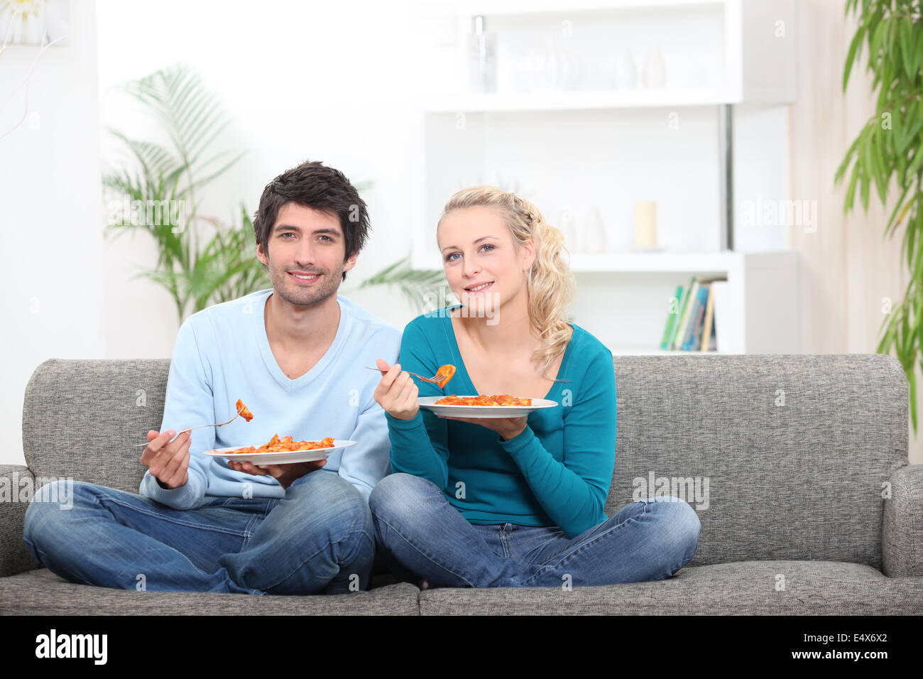 Couple having dinner on their couch Stock Photo