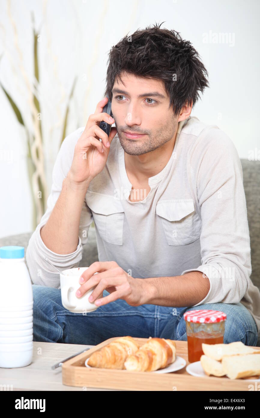Man making a phone call over breakfast Stock Photo