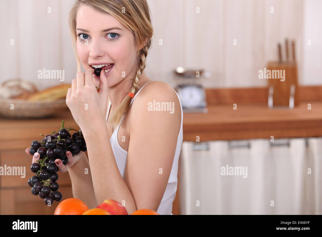 Blonde woman eating grapes Stock Photo Alamy