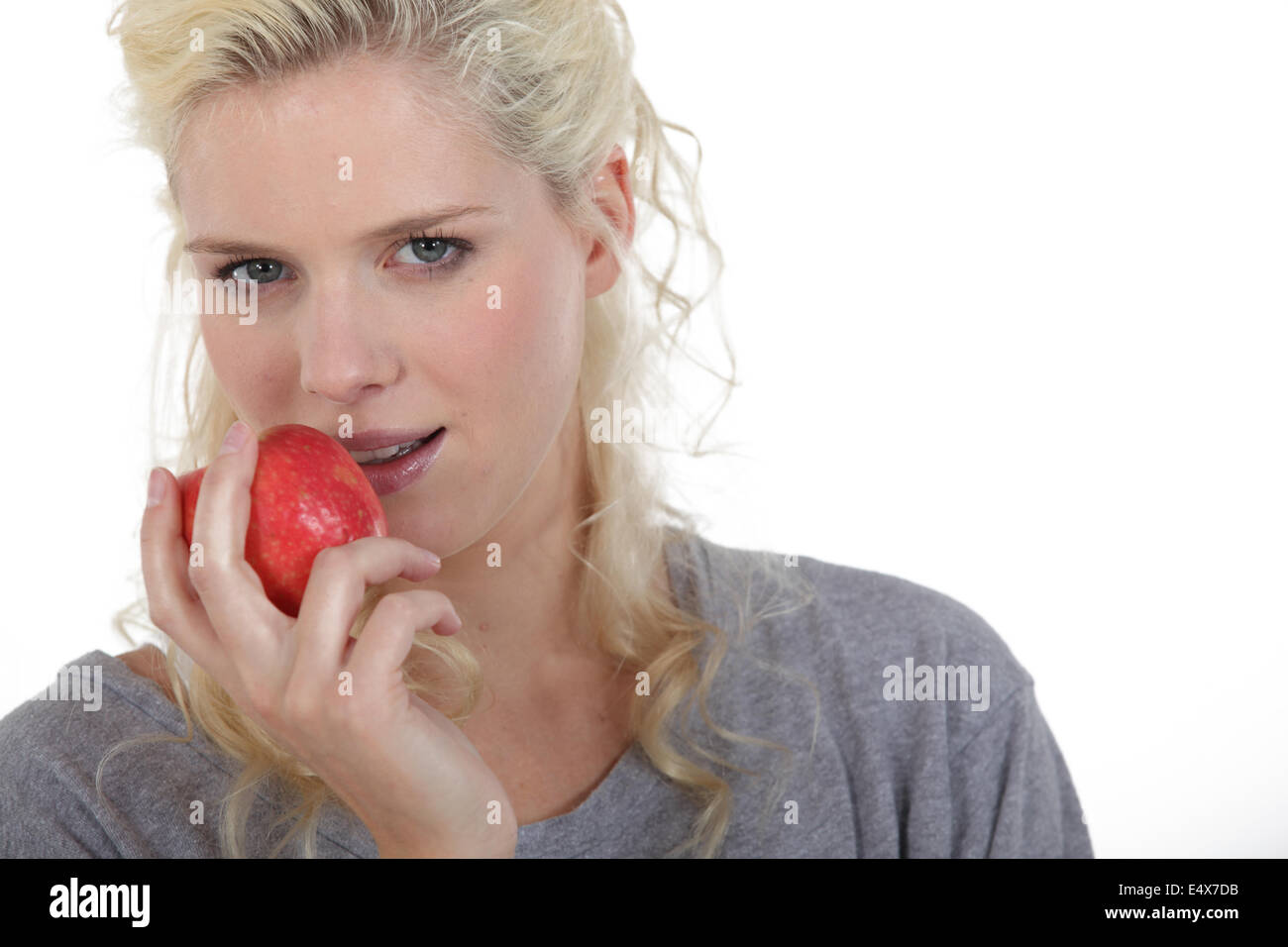 Blond woman eating red apple Stock Photo Alamy