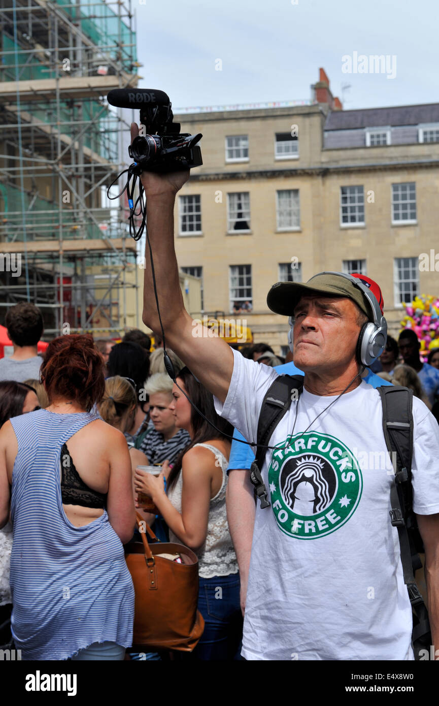 Man filming with a Panasonic HDC-HS300 camera holding it above his head at Bristol St Paul's street festival, UK Stock Photo