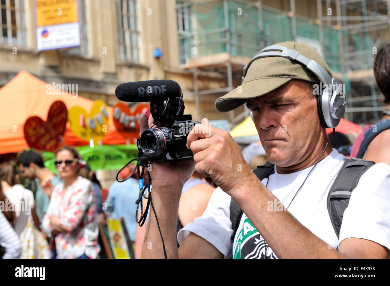 Man filming with a Panasonic HDC-HS300 camera hand holding it at Bristol St Paul's street festival, UK Stock Photo