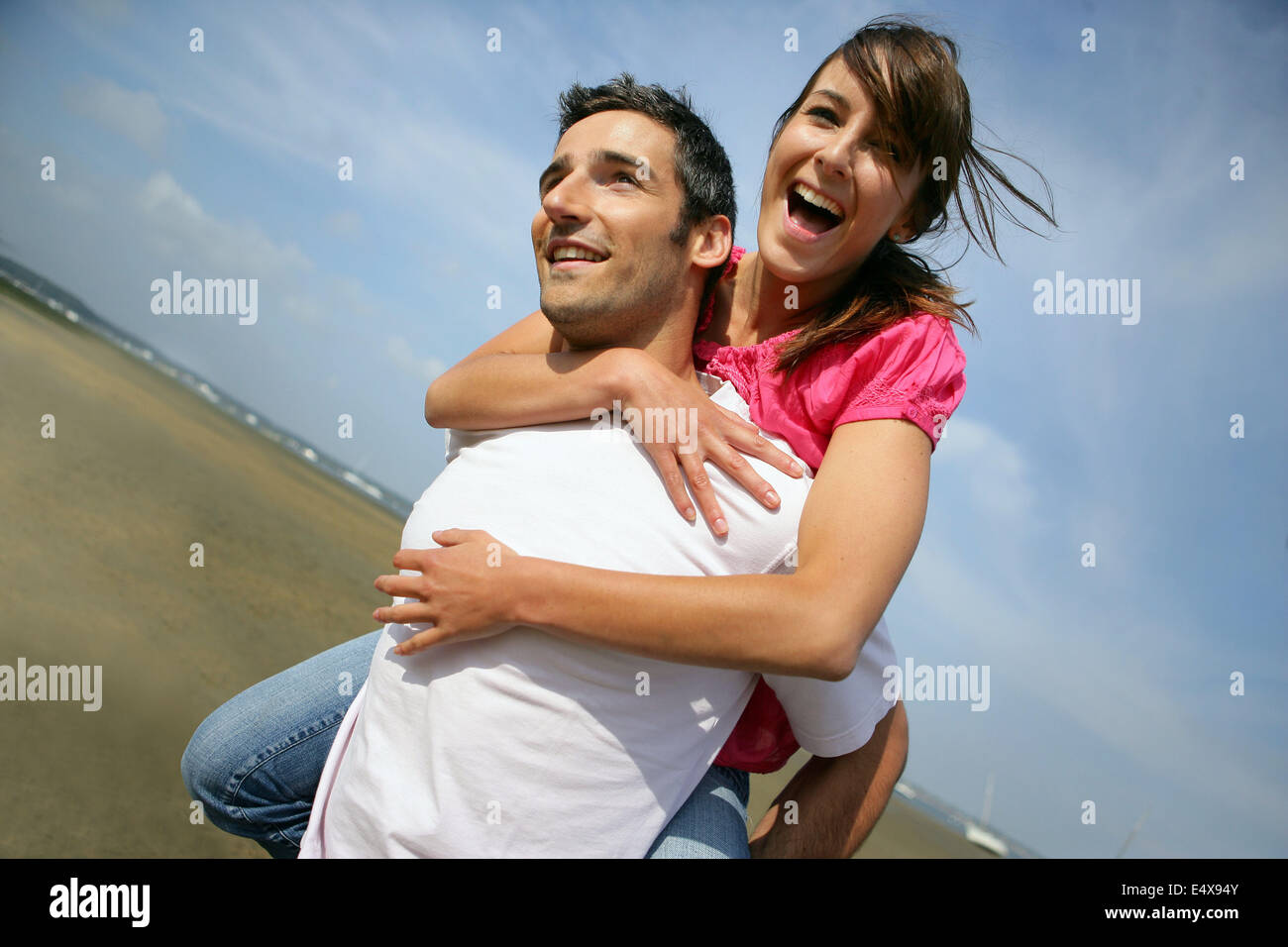 Young couple enjoying piggyback ride isolated on gray background Stock  Photo - Alamy