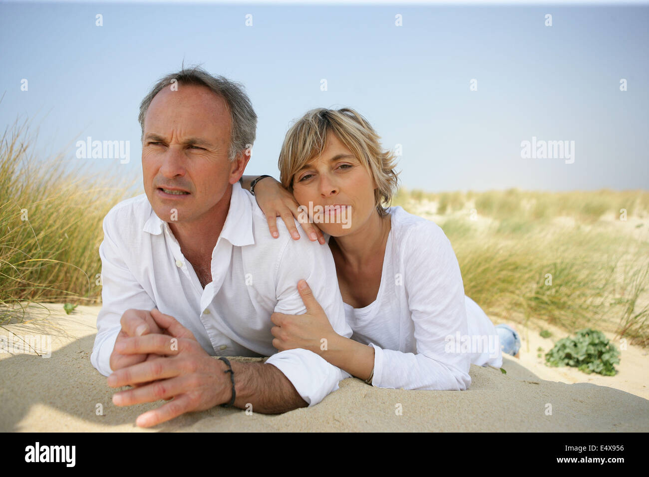 Couple lying in a sand dune Stock Photo