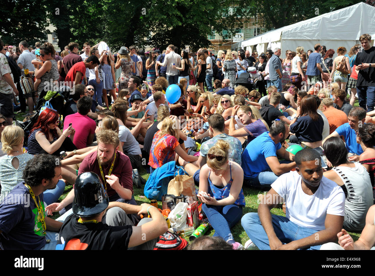 Crowd sitting relaxing in park at Bristol St Paul's street festival, UK Stock Photo