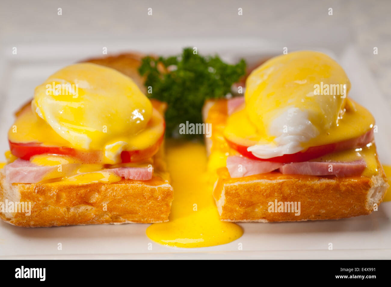eggs benedict on bread with tomato and ham Stock Photo Alamy