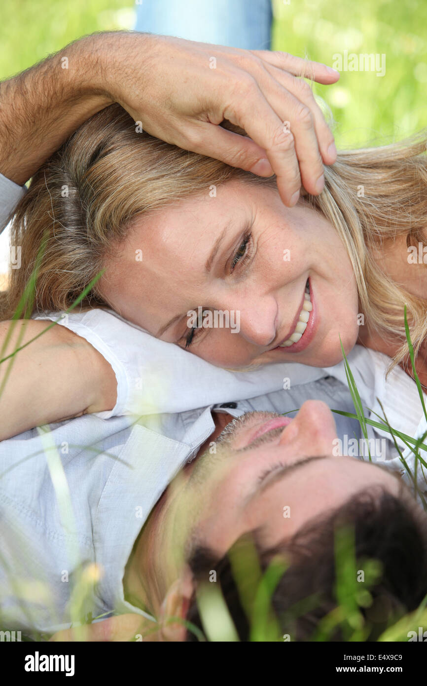 Couple lying in the grass Stock Photo - Alamy