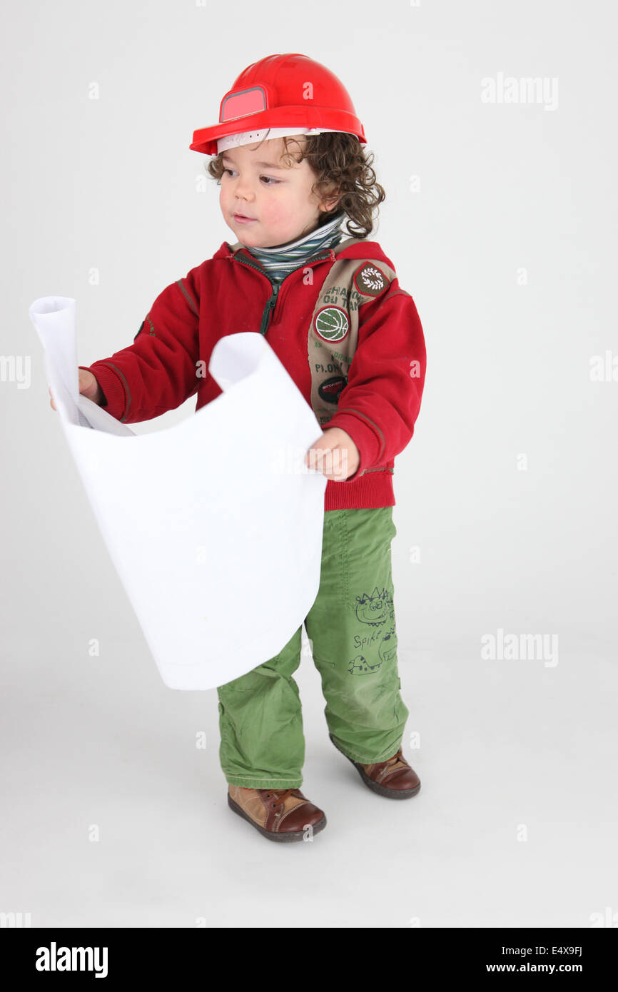Little boy dressed as builder holding plans Stock Photo