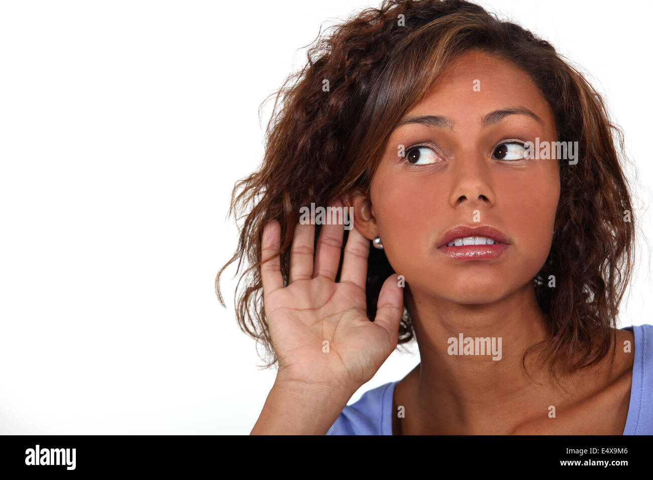 Woman holding hand to ear Stock Photo