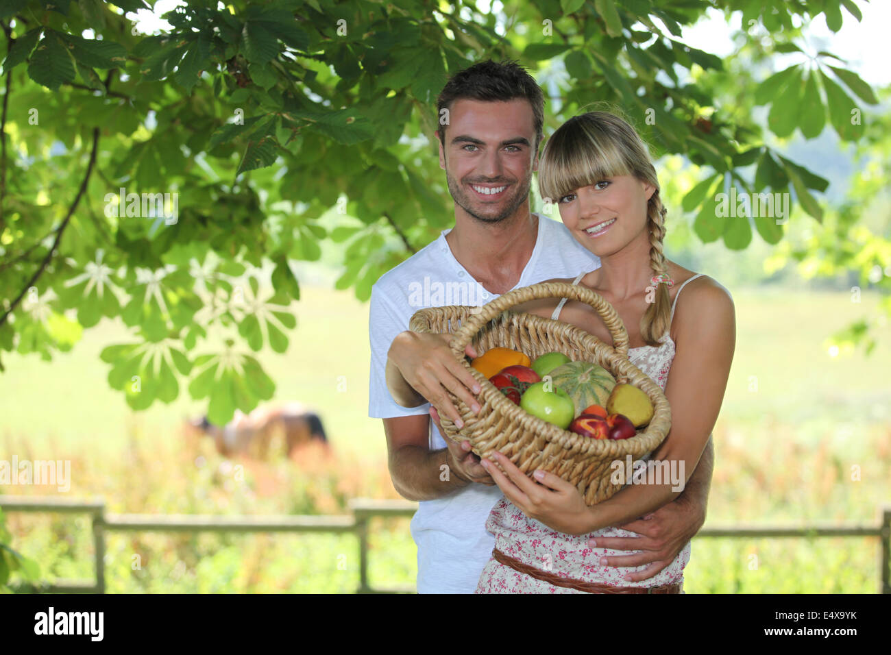Couple with a basket of fruits Stock Photo Alamy