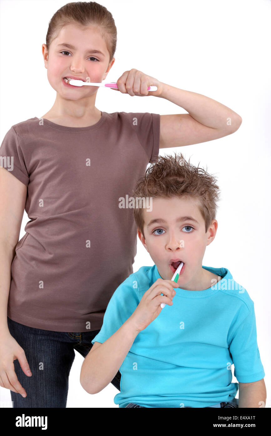 little boy and girl brushing their teeth Stock Photo