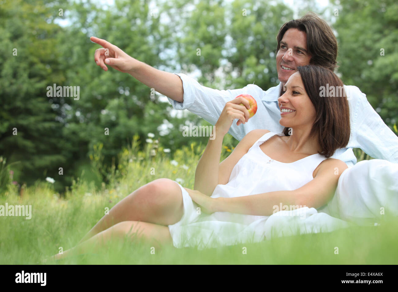 Couple sitting in the grass Stock Photo - Alamy