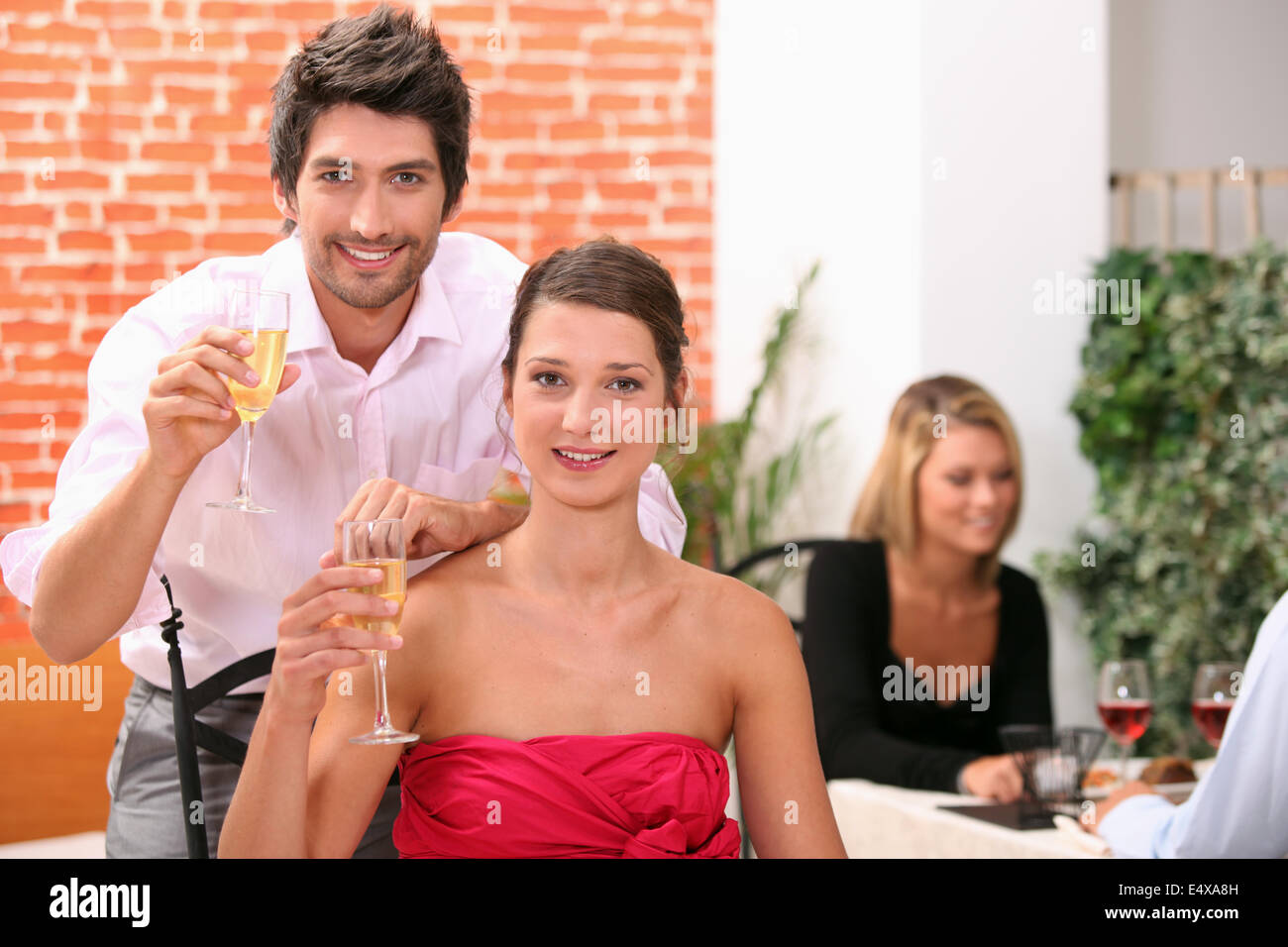 Couple holding champagne flutes in restaurant Stock Photo Alamy
