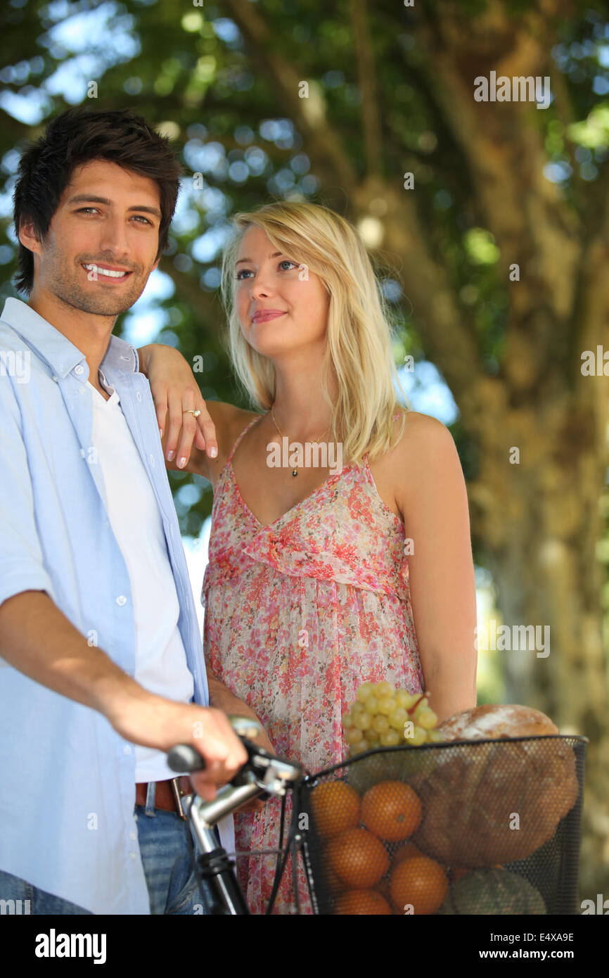 Couple with a bike and basket of produce Stock Photo