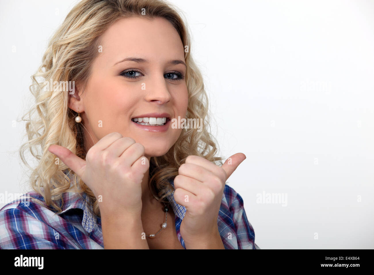 blond woman doing thumbs-up gesture Stock Photo