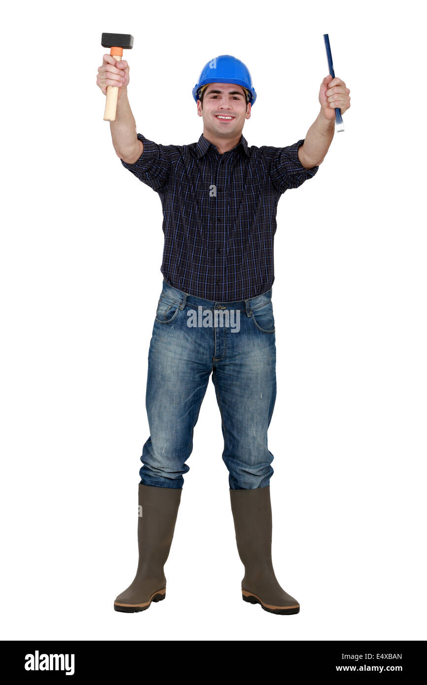 Tradesman holding a hammer and chisel Stock Photo