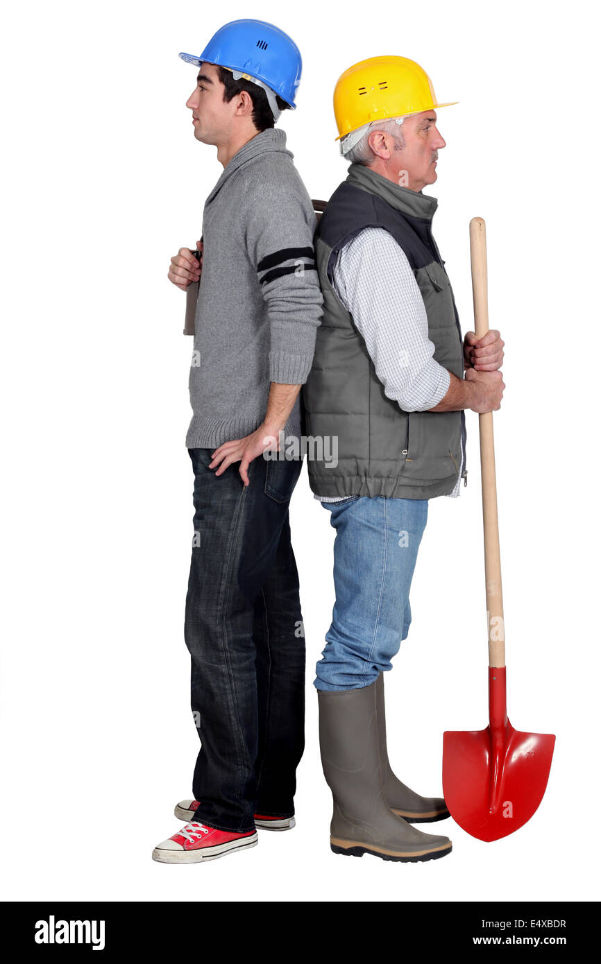 Manual workers standing back to back Stock Photo