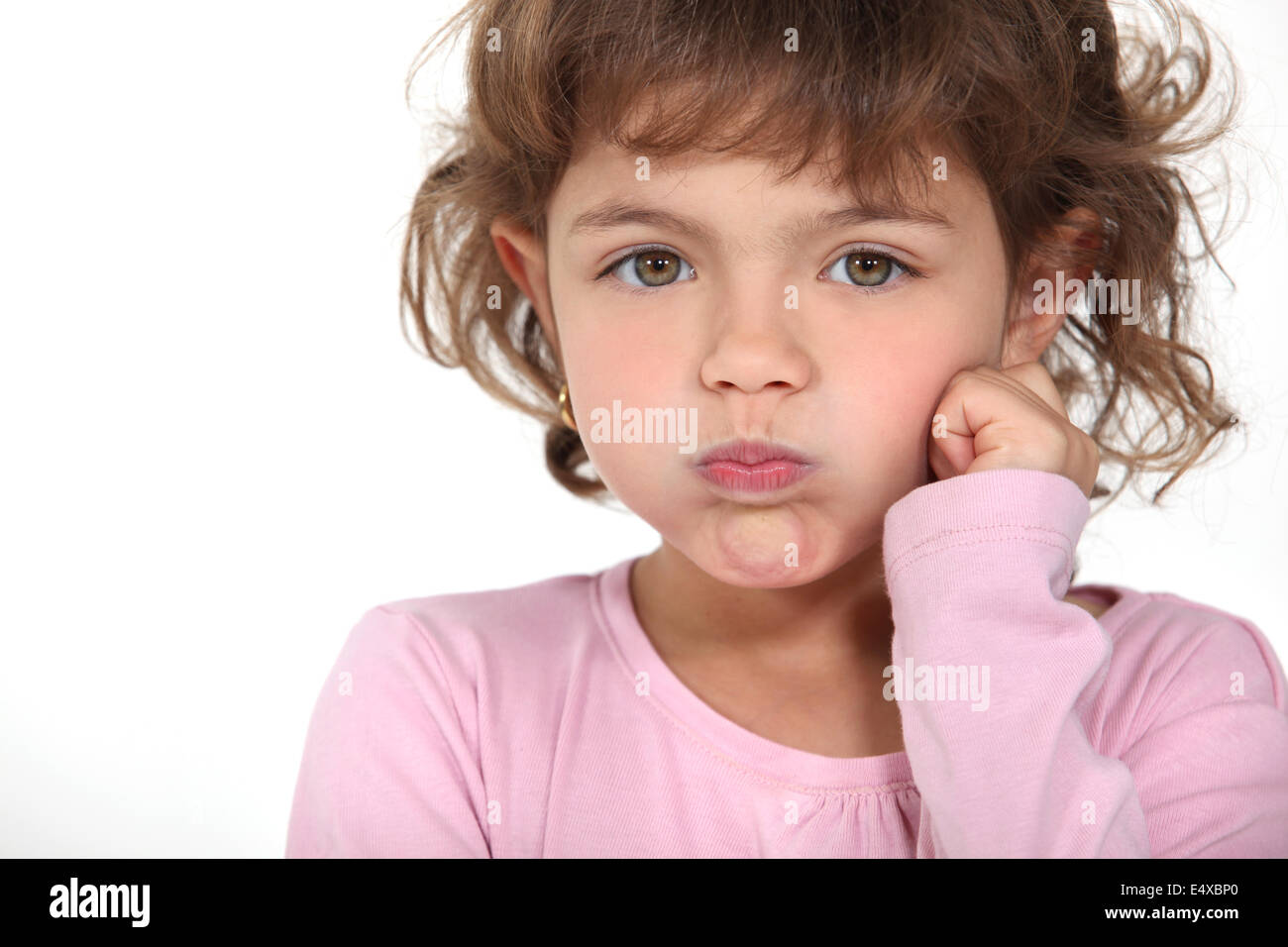 Little girl blowing her cheeks Stock Photo