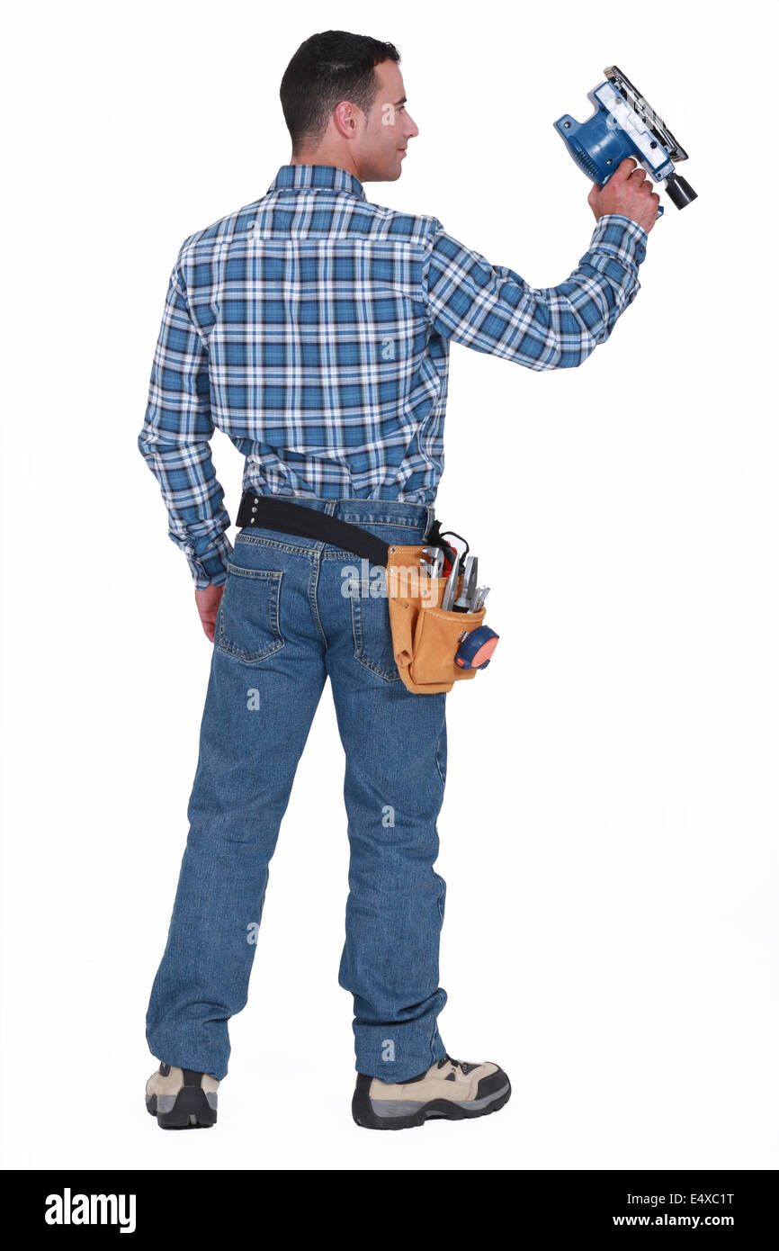 Rear view of a man with a sander Stock Photo