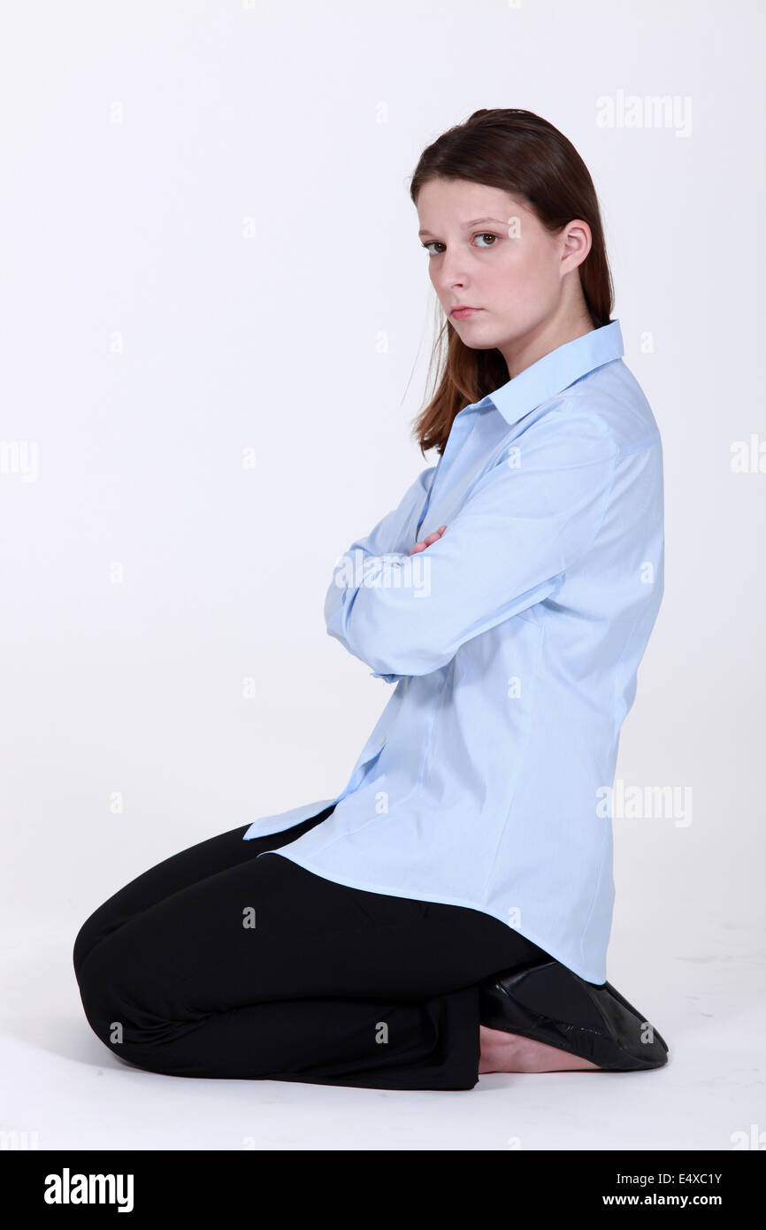 woman kneeling down cross-armed looking sulky Stock Photo