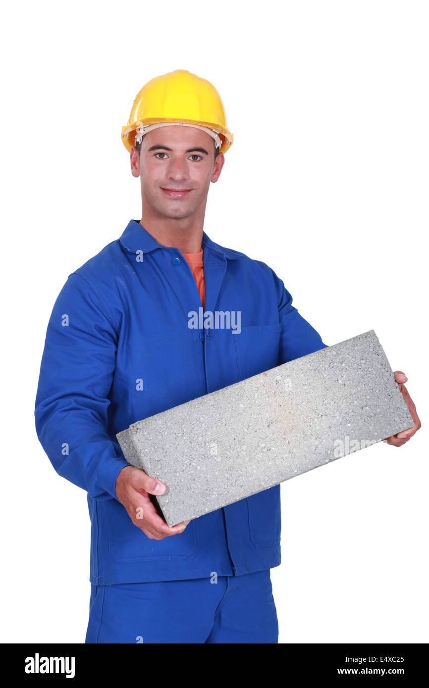 Tradesman carrying a cinder block Stock Photo