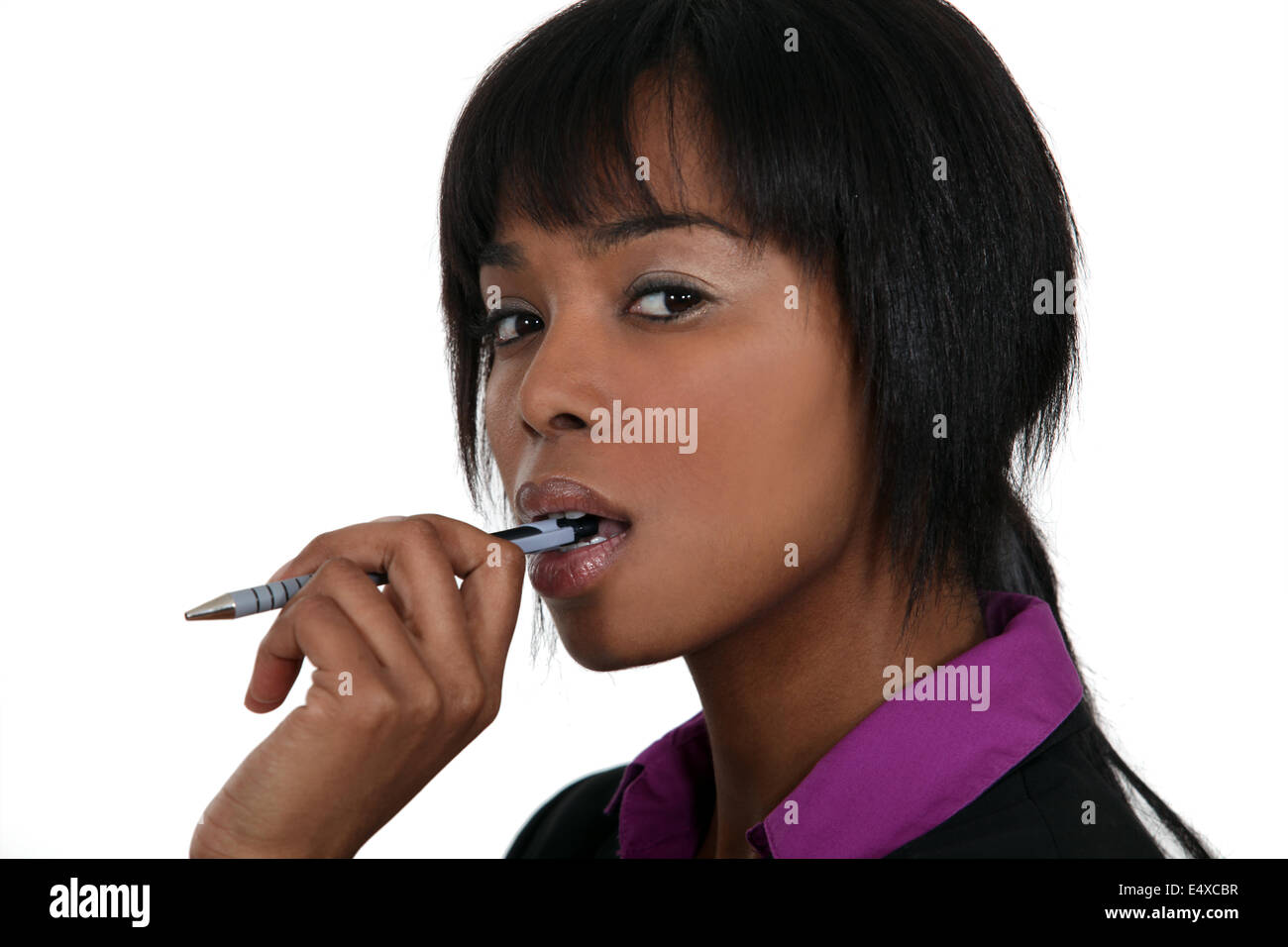 A pensive woman chewing on her pen Stock Photo