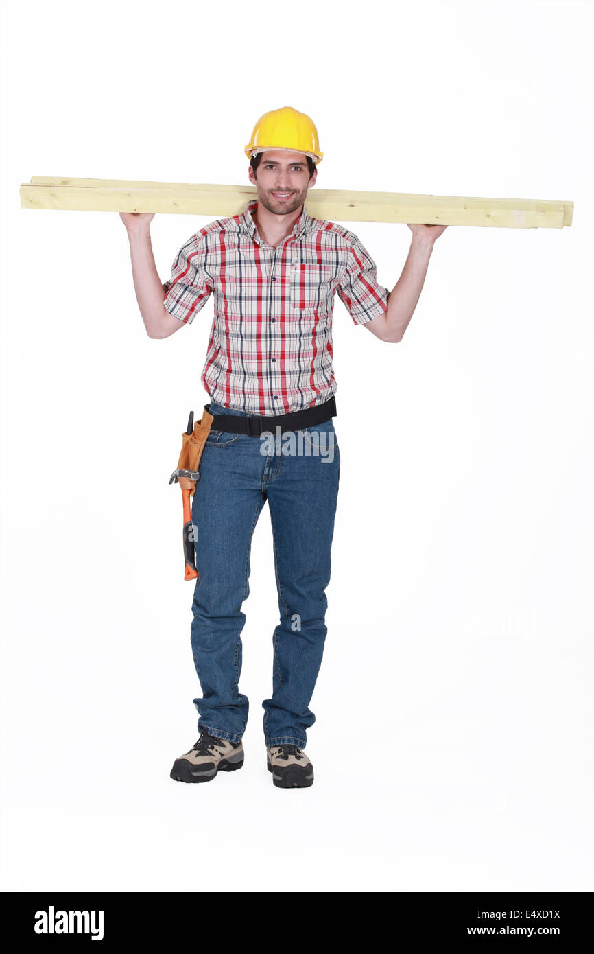 Tradesman carrying planks of wood Stock Photo