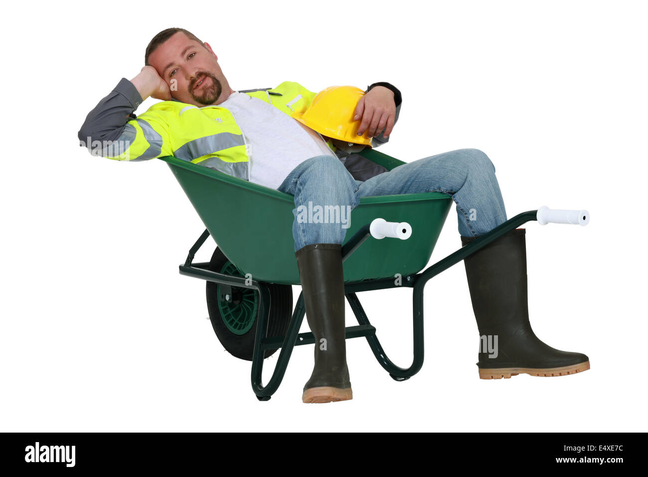 Lazy worker slumped in wheelbarrow Stock Photo