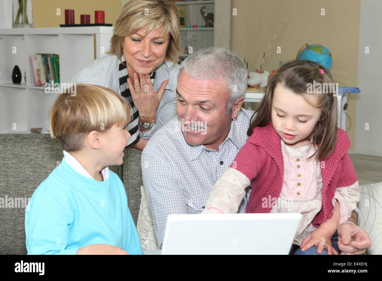 pensioners with grandchildren using computer Stock Photo
