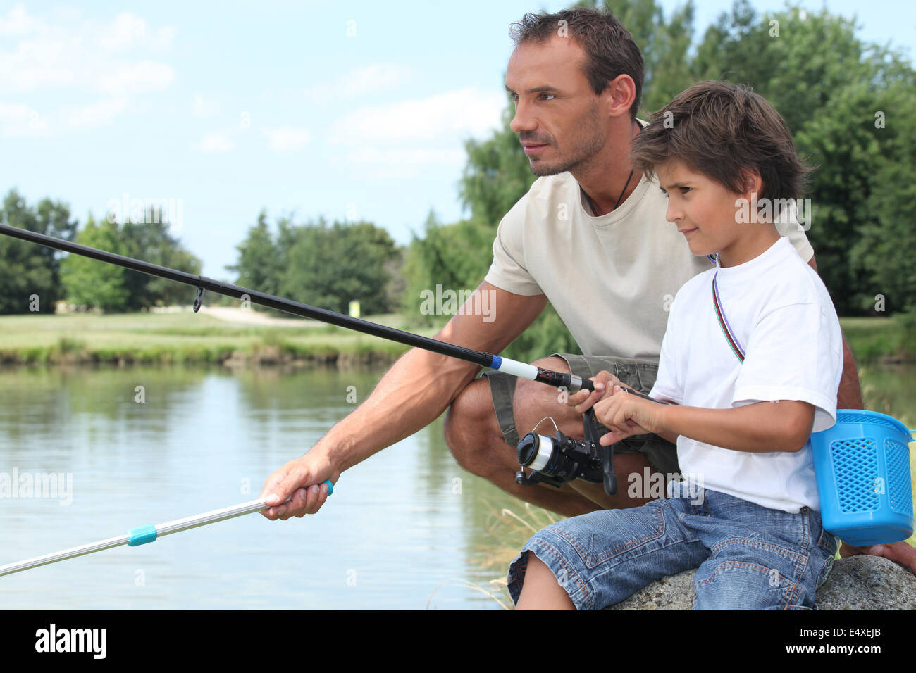 Father and son fishing together on dock - Stock Image - F004/1897
