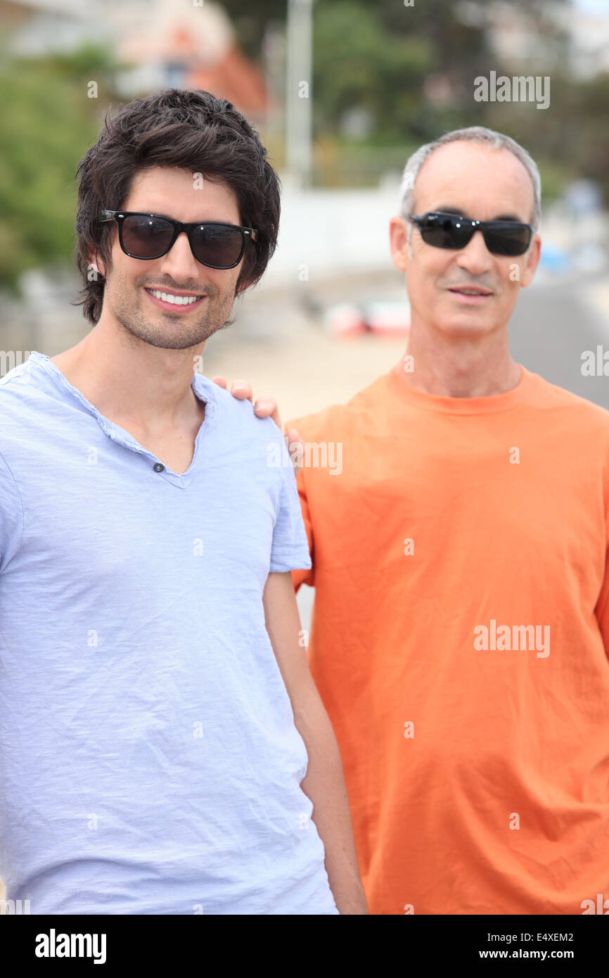 Father and grownup son wearing shades Stock Photo
