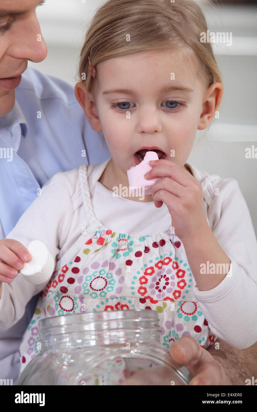 Little girl eating marshmallows with her dad Stock Photo Alamy