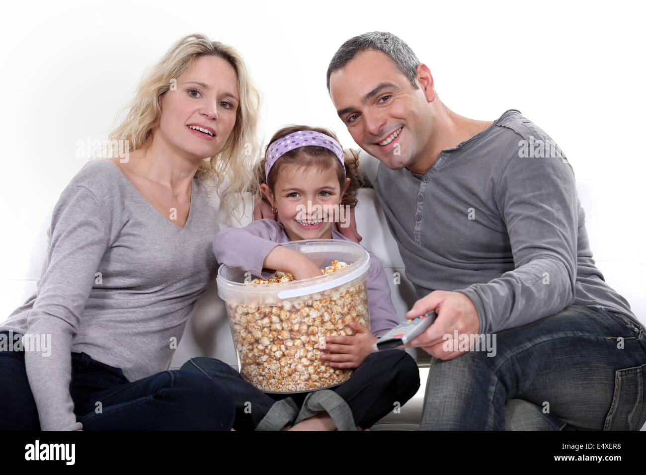 Family eating popcorn on a sofa Stock Photo
